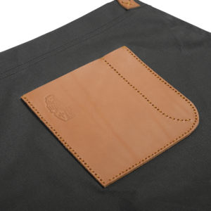 Detailansicht der La Marzocco Barista-Schürze aus robustem, wasserdichtem Segeltuch mit hochwertiger Lederapplikation.