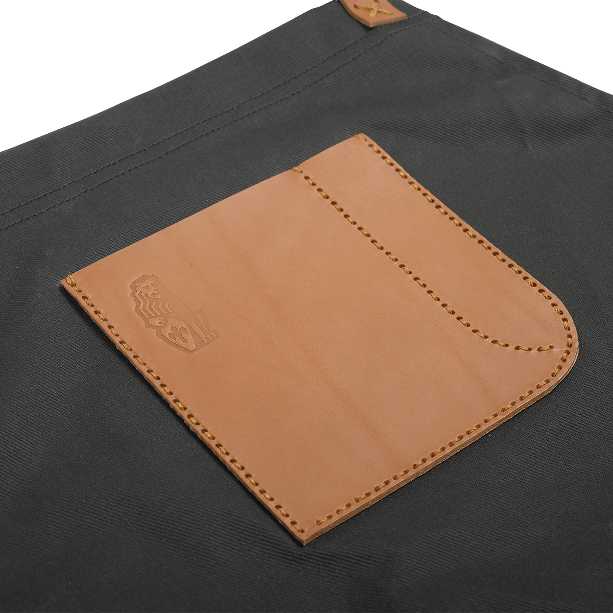 Detailansicht der La Marzocco Barista-Schürze aus robustem, wasserdichtem Segeltuch mit hochwertiger Lederapplikation.