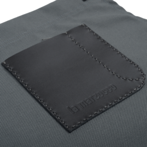 Detailansicht der La Marzocco Barista-Schürze aus robustem, wasserdichtem Segeltuch mit hochwertiger Lederapplikation.